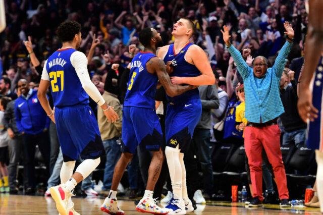 Denver Nuggets center Nikola Jokic (15) is congratulated for his three point basket by forward Will Barton (5) and guard Jamal Murray (27) in the fourth quarter against the Philadelphia 76ers at the Pepsi Center.