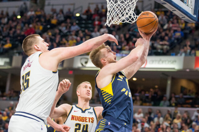 Denver Nuggets center Nikola Jokic (15) fouls Indiana Pacers forward Domantas Sabonis (11) while shooting in the second half at Bankers Life Fieldhouse.