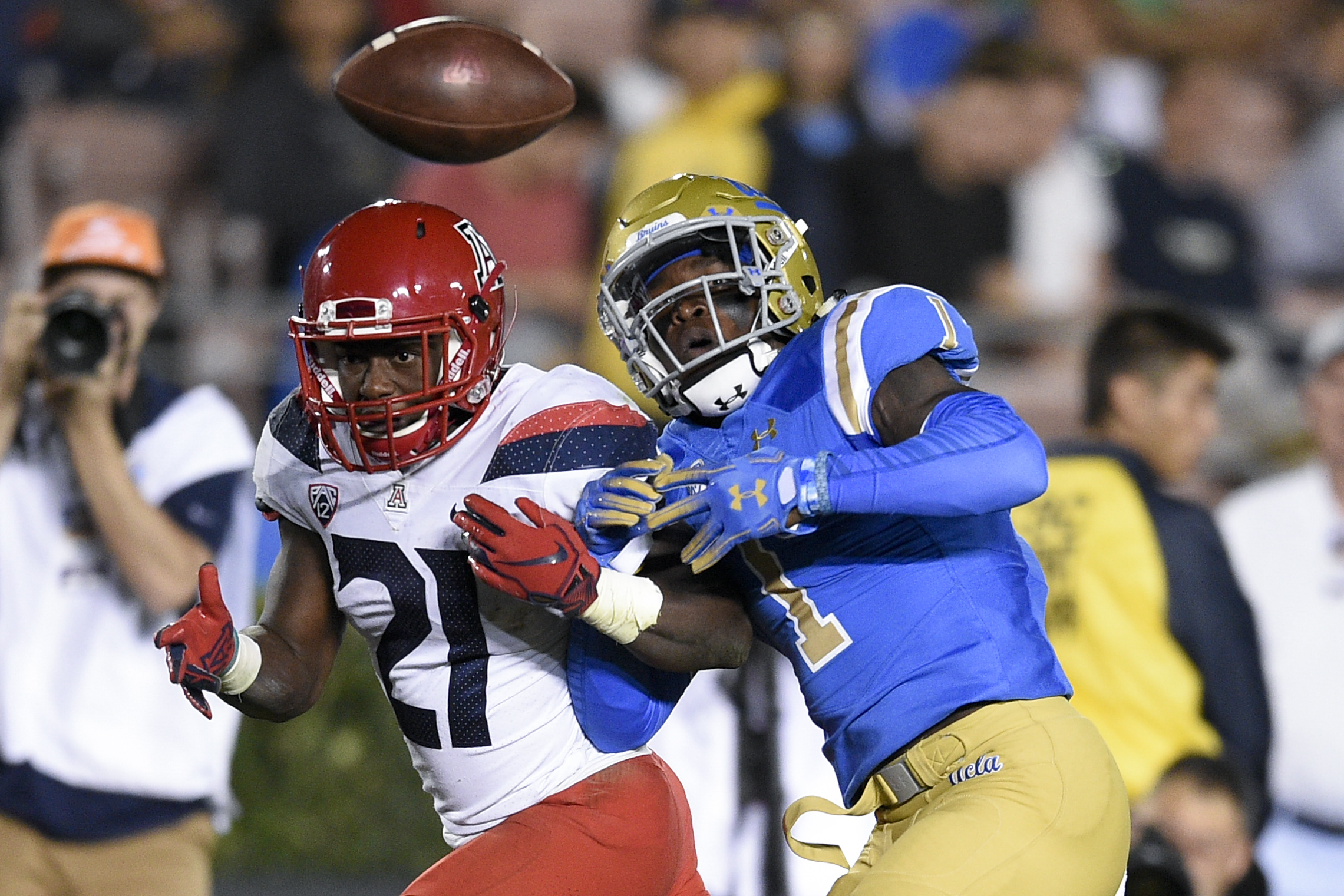 UCLA Bruins defensive back Darnay Holmes (1) knocks the ball away from Arizona Wildcats running back J.J. Taylor (21) for a fumble during the first half at Rose Bowl. 
