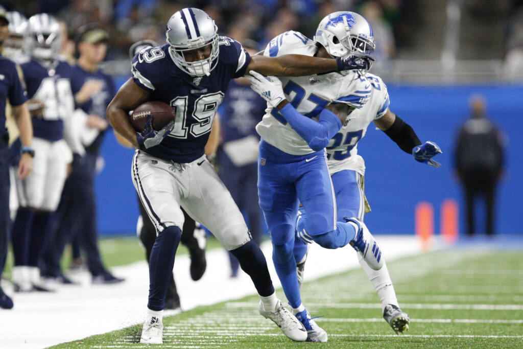 Dallas Cowboys wide receiver Amari Cooper (19) stiff arms Detroit Lions cornerback Justin Coleman (27) after a catch during the fourth quarter at Ford Field.