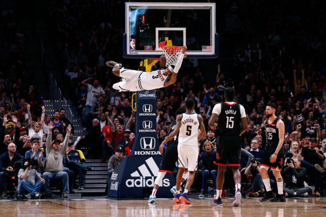 Denver Nuggets forward Torrey Craig (3) hangs off the rim after dunking the ball as forward Will Barton III (5) and Houston Rockets center Clint Capela (15) and guard Austin Rivers (25) look on in the fourth quarter at the Pepsi Center.