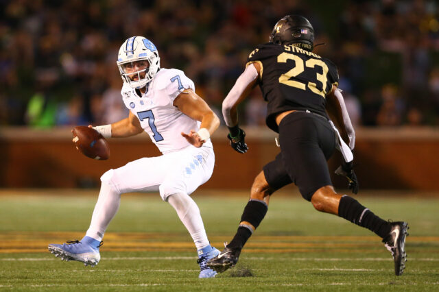North Carolina Tar Heels quarterback Sam Howell (7) tries to avoid being sacked by Wake Forest Demon Deacons linebacker Justin Strnad (23) during the third quarter at BB&T Field.