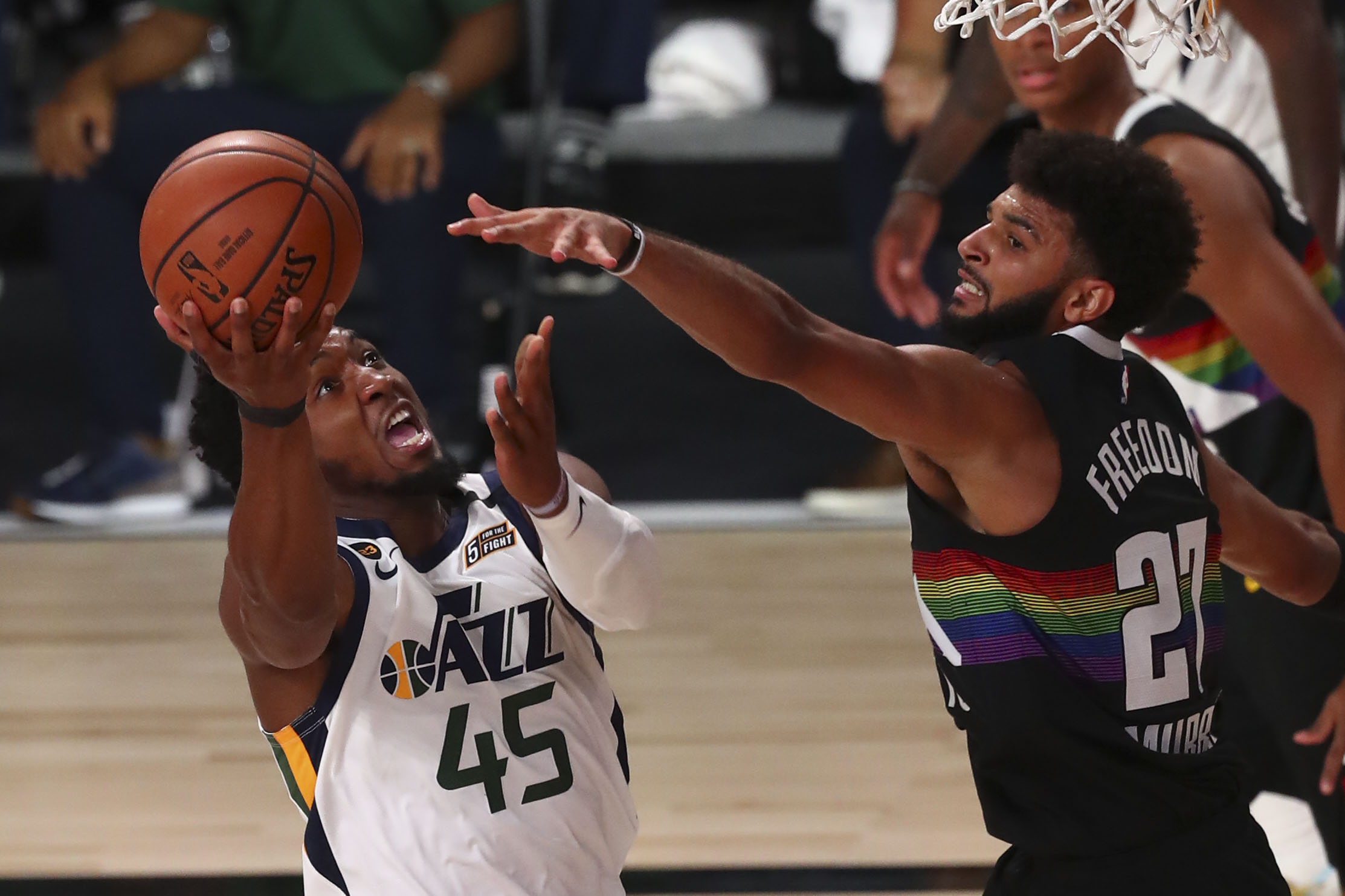 Florida, USA; Utah Jazz guard Donovan Mitchell (45) shoots the basketball against Denver Nuggets guard Jamal Murray (27) in game two of the first round of the 2020 NBA Playoffs at AdventHealth Arena.