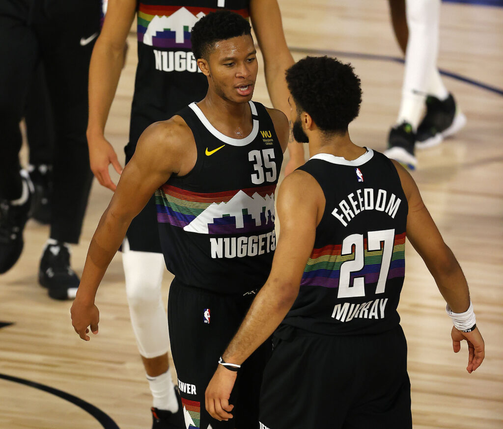 Jamal Murray #27 of the Denver Nuggets and PJ Dozier #35 of the Denver Nuggets react after their win over Utah Jazz in game five of the first round of the 2020 NBA Playoffs at ESPN Wide World of Sports Complex.