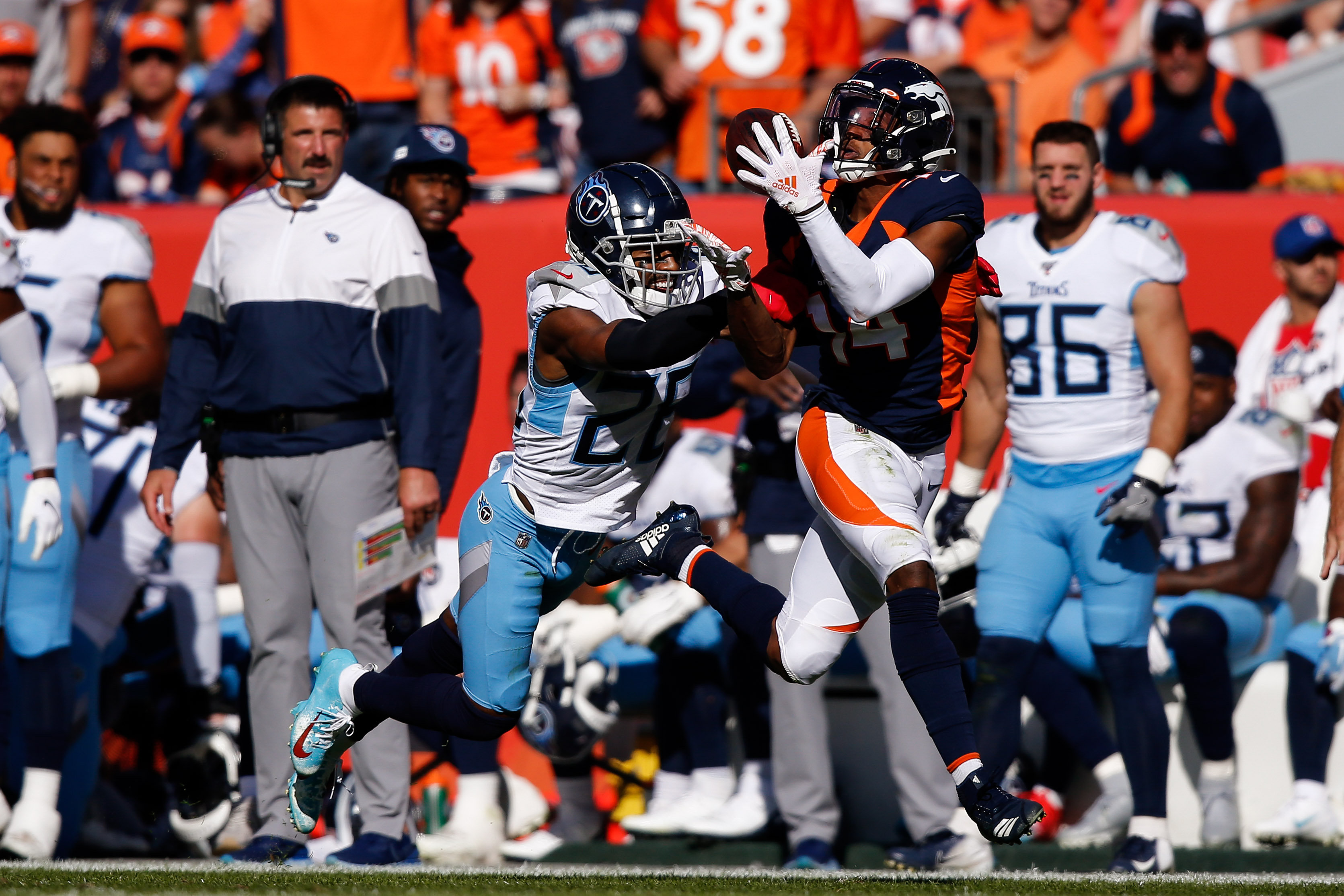 Denver Broncos wide receiver Courtland Sutton (14) makes a catch under pressure from Tennessee Titans cornerback Logan Ryan (26) in the second quarter at Empower Field at Mile High. Mandatory Credit