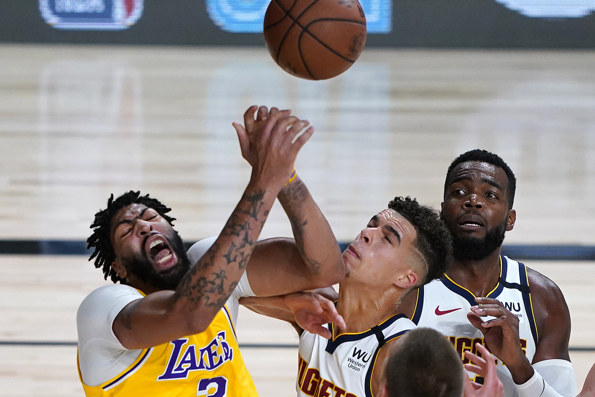 Los Angeles Lakers' Anthony Davis, left, battles Denver Nuggets' Michael Porter Jr. during the first half of an NBA basketball game Monday, Aug. 10, 2020, in Lake Buena Vista, Fla. at AdventHealth Arena.