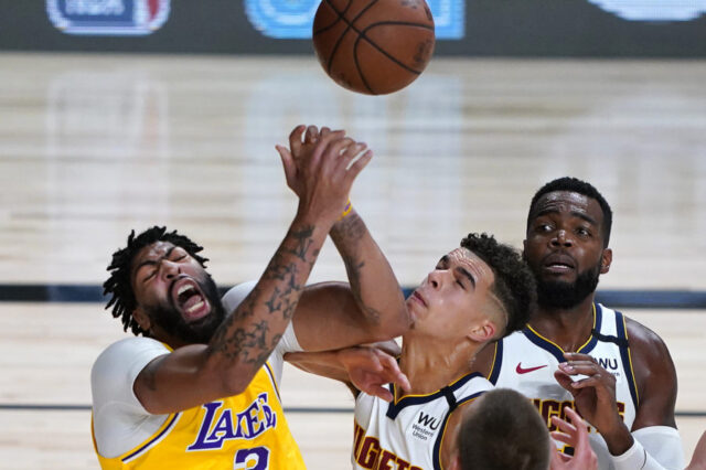 Los Angeles Lakers' Anthony Davis, left, battles Denver Nuggets' Michael Porter Jr. during the first half of an NBA basketball game Monday, Aug. 10, 2020, in Lake Buena Vista, Fla. at AdventHealth Arena.