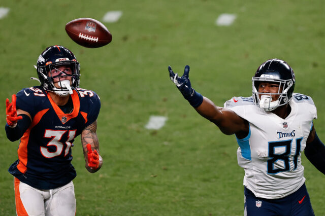 Denver Broncos free safety Justin Simmons (31) attempts to grab a pass intended for Tennessee Titans tight end Jonnu Smith (81) in the third quarter at Empower Field at Mile High.