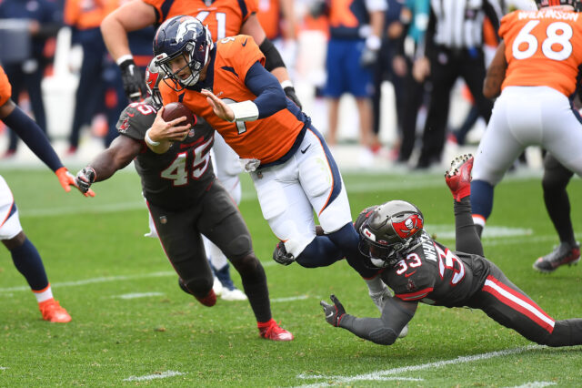 Tampa Bay Buccaneers inside linebacker Devin White (45) and free safety Jordan Whitehead (33) sack Denver Broncos quarterback Jeff Driskel (9) in the second quarter at Empower Field at Mile High.