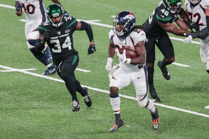 Denver Broncos running back Melvin Gordon (25) carries the ball as New York Jets cornerback Brian Poole (34) pursues during the second half at MetLife Stadium.