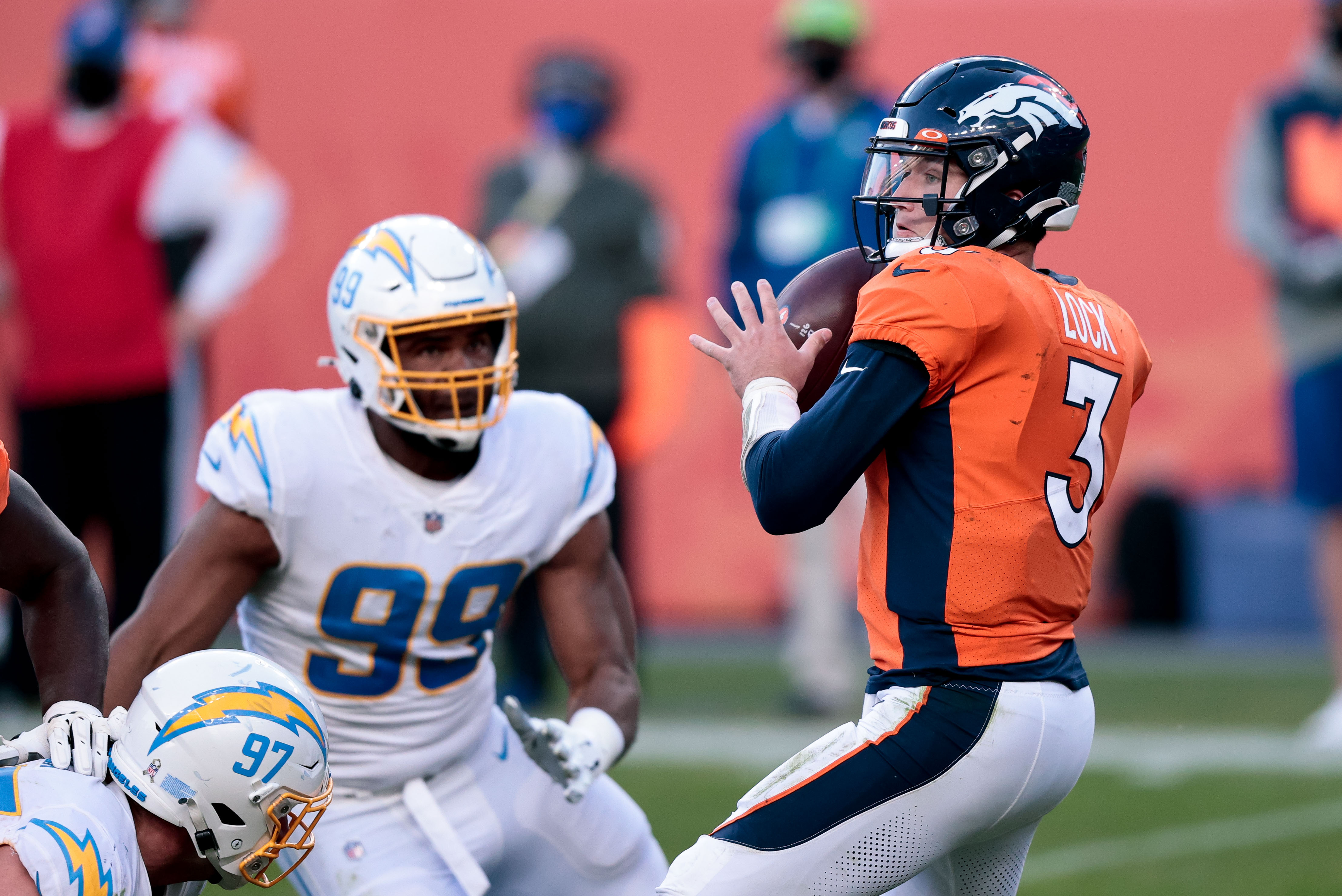 Denver Broncos quarterback Drew Lock (3) looks to pass under pressure from Los Angeles Chargers defensive tackle Jerry Tillery (99) in the third quarter at Empower Field at Mile High