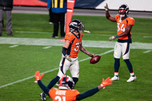 Denver Broncos safety Justin Simmons (31) celebrates his interception against the Miami Dolphins as cornerback A.J. Bouye (21) and cornerback Essang Bassey (34) react in the fourth quarter at Empower Field at Mile High.