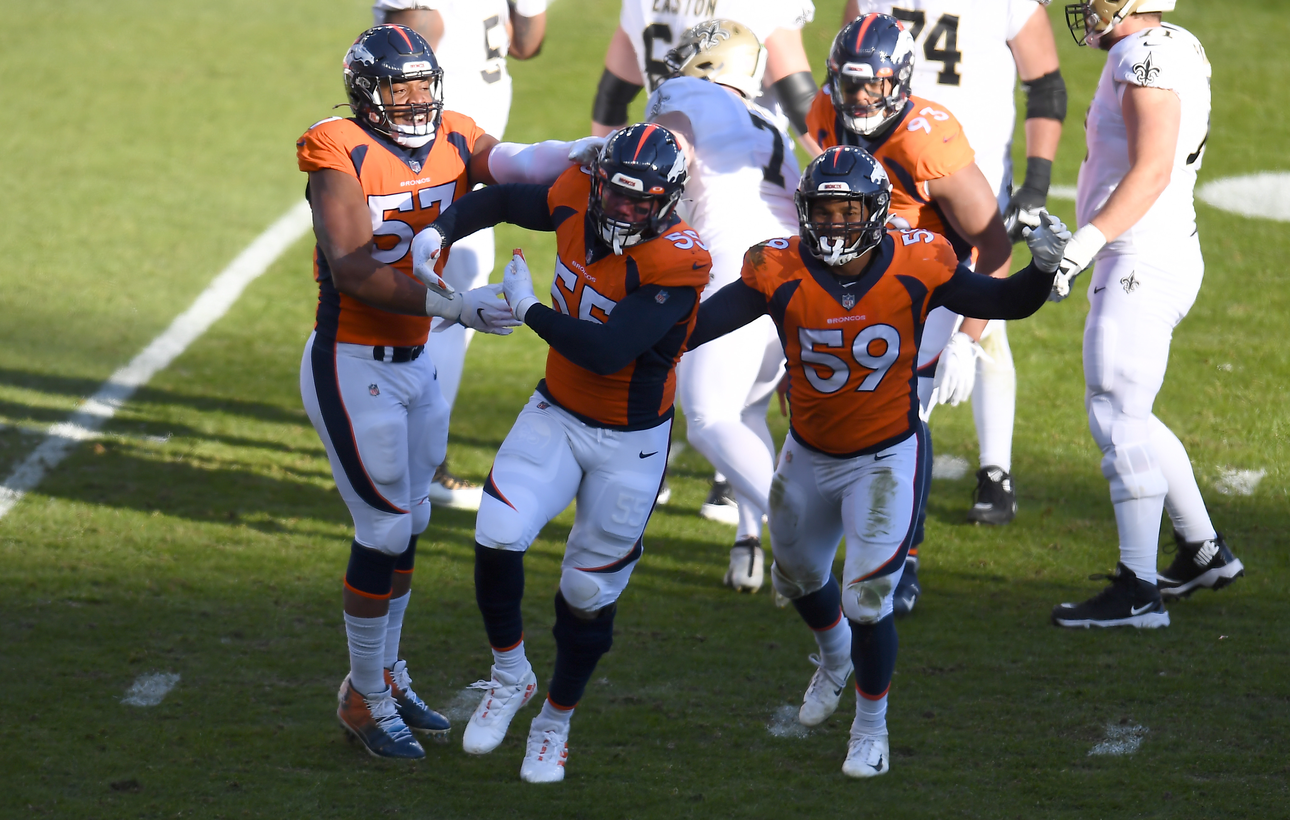 Denver Broncos outside linebacker Bradley Chubb (55) celebrates his sack with outside linebacker Malik Reed (59) and defensive end DeMarcus Walker (57) in the first quarter against the New Orleans Saints at Empower Field at Mile High.