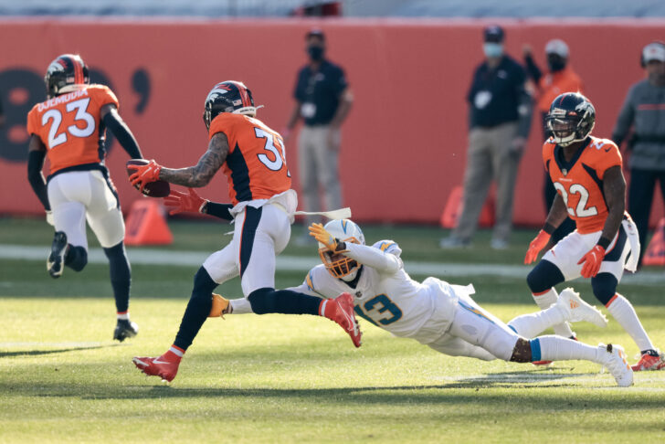 Los Angeles Chargers wide receiver Keenan Allen (13) moves in against Denver Broncos safety Justin Simmons (31) as he returns an interception in the first quarter at Empower Field at Mile High
