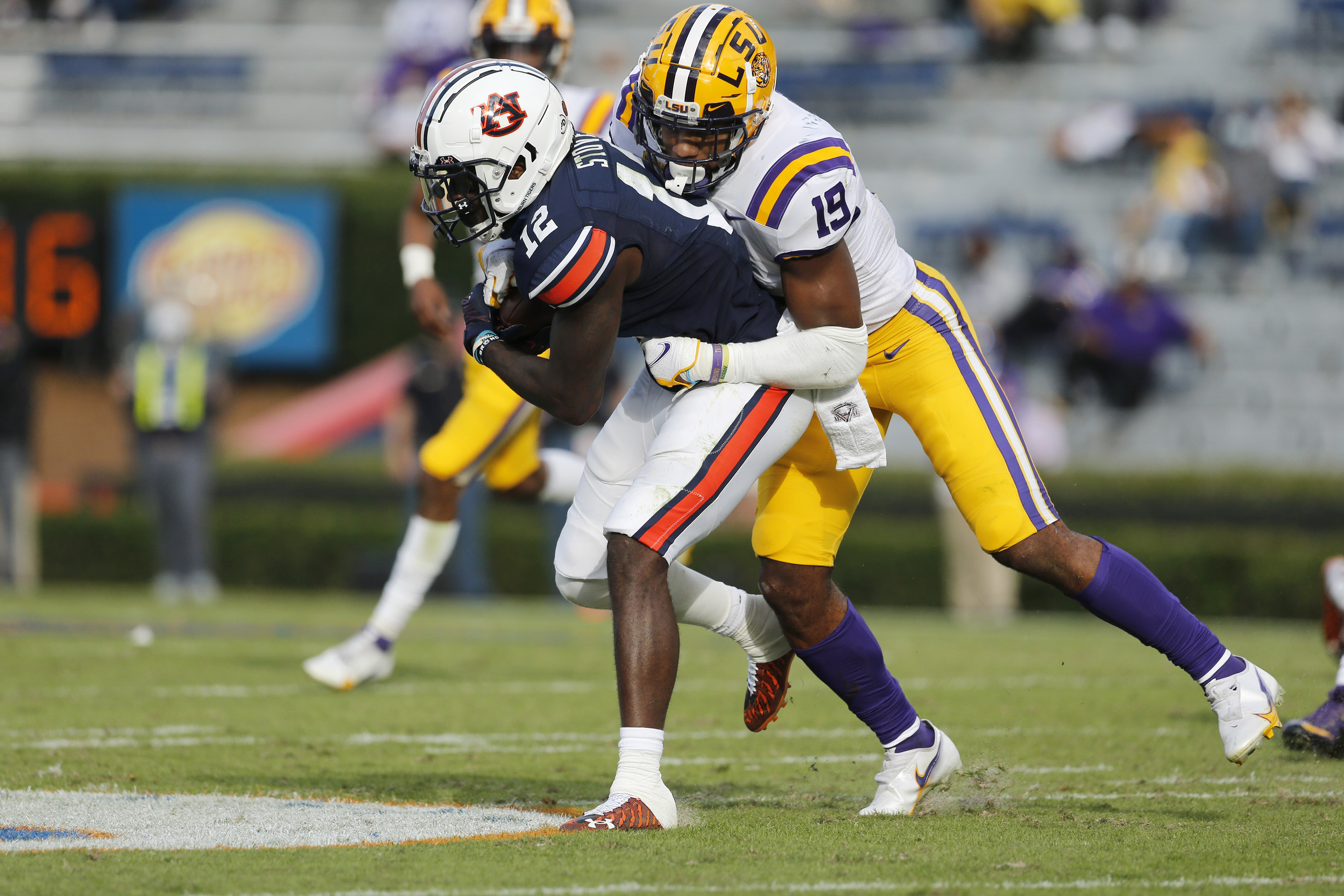 Auburn Tigers receiver Eli Stove (12) is tackled by LSU Tigers linebacker Jabril Cox (21) during the second quarter at Jordan-Hare Stadium.