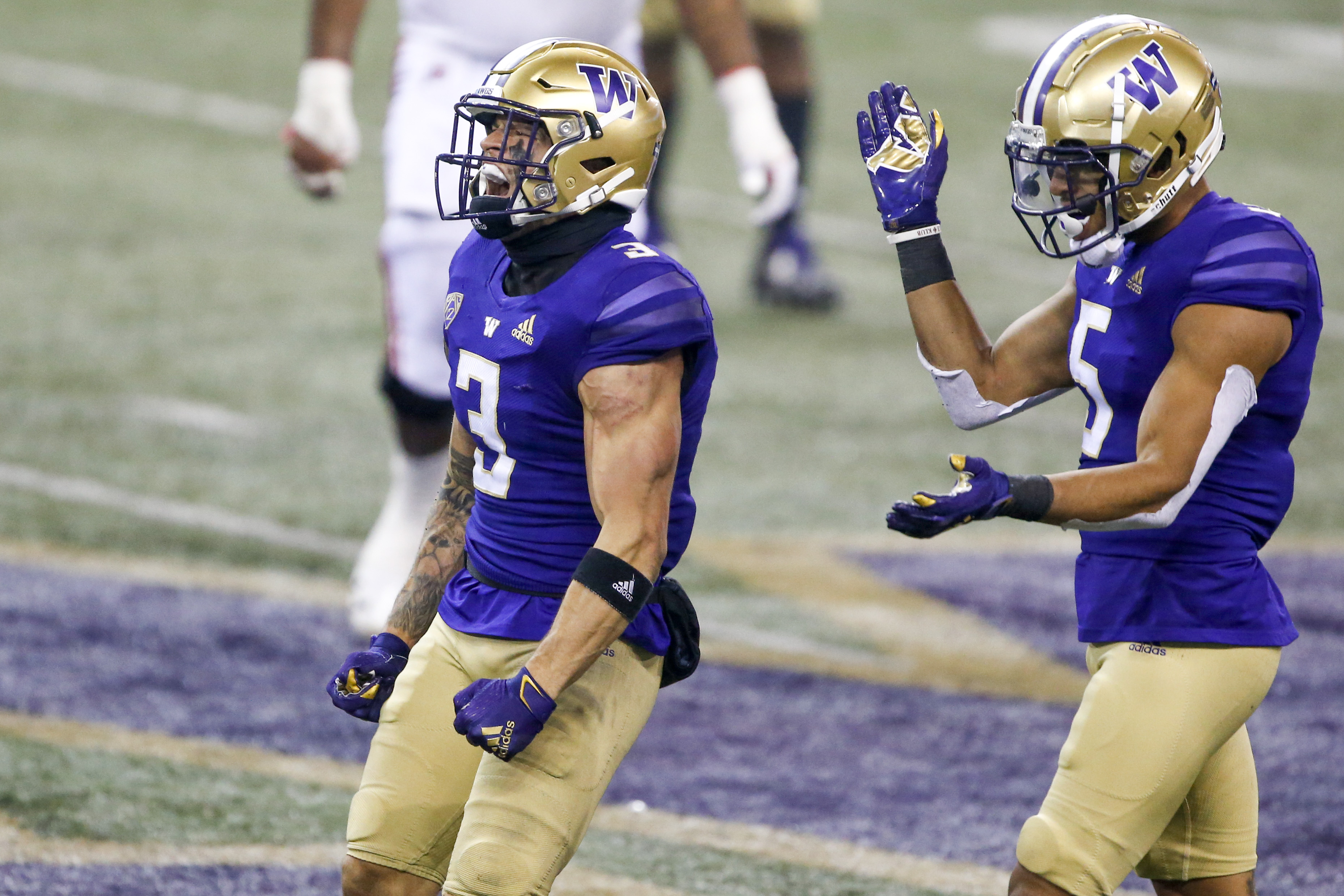 Washington Huskies defensive back Elijah Molden (3) and defensive back Alex Cook (5) react following a third down stop against the Utah Utes during the fourth quarter at Alaska Airlines Field at Husky Stadium.