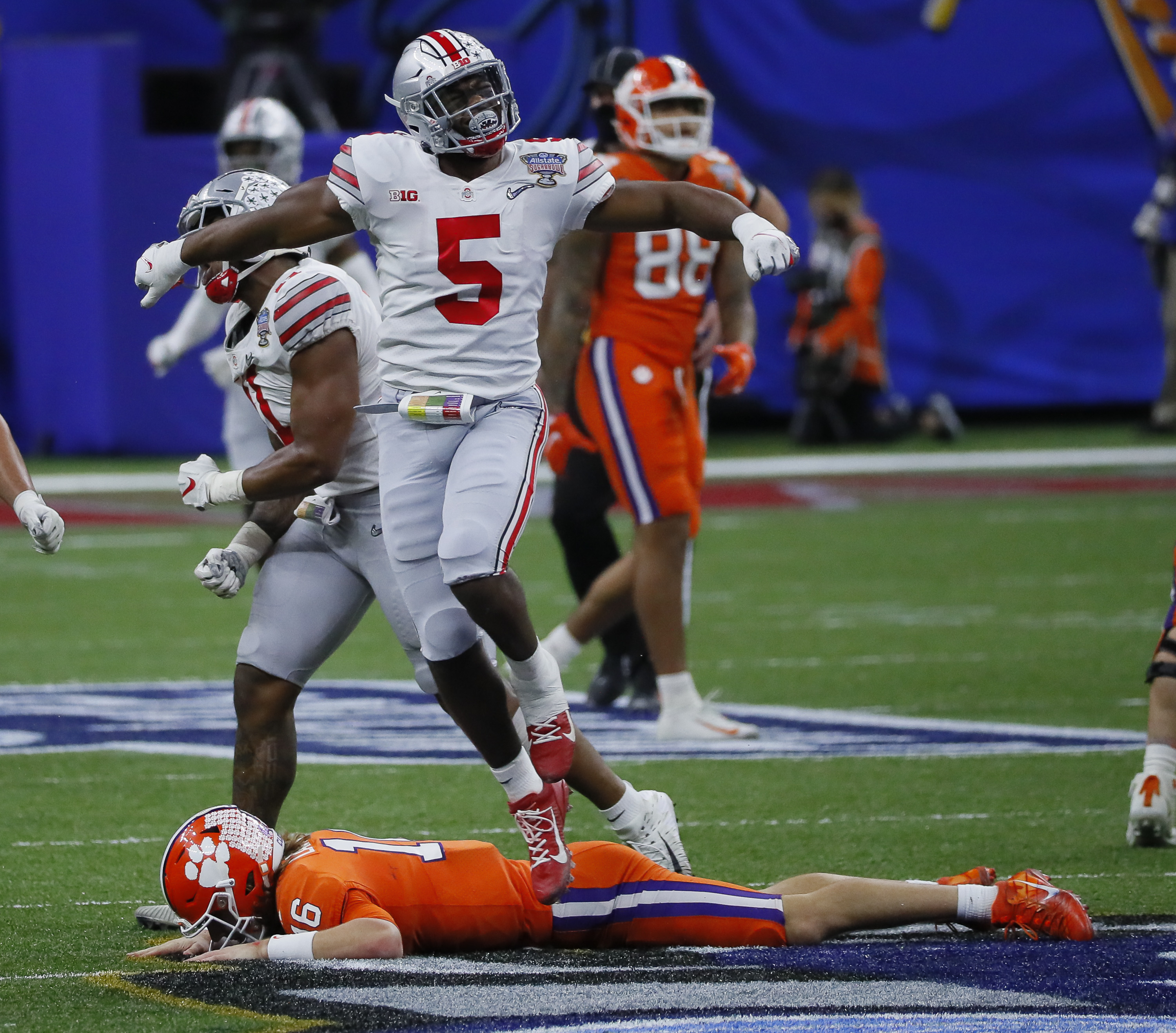 Ohio State Buckeyes linebacker Baron Browning (5) celebrates a fourth down stop as he leaps over Clemson Tigers quarterback Trevor Lawrence (16) during the fourth quarter of the College Football Playoff semifinal at the Allstate Sugar Bowl in the Mercedes-Benz Superdome in New Orleans on Friday, Jan. 1, 2021. Ohio State won 49-28