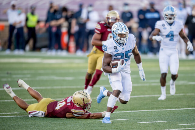 North Carolina Tar Heels running back Javonte Williams (25) avoids the tackle of Boston College Eagles Sam Johnson III (14) and scores a 41-yard receiving touchdown during the second quarter at Alumni Stadium.