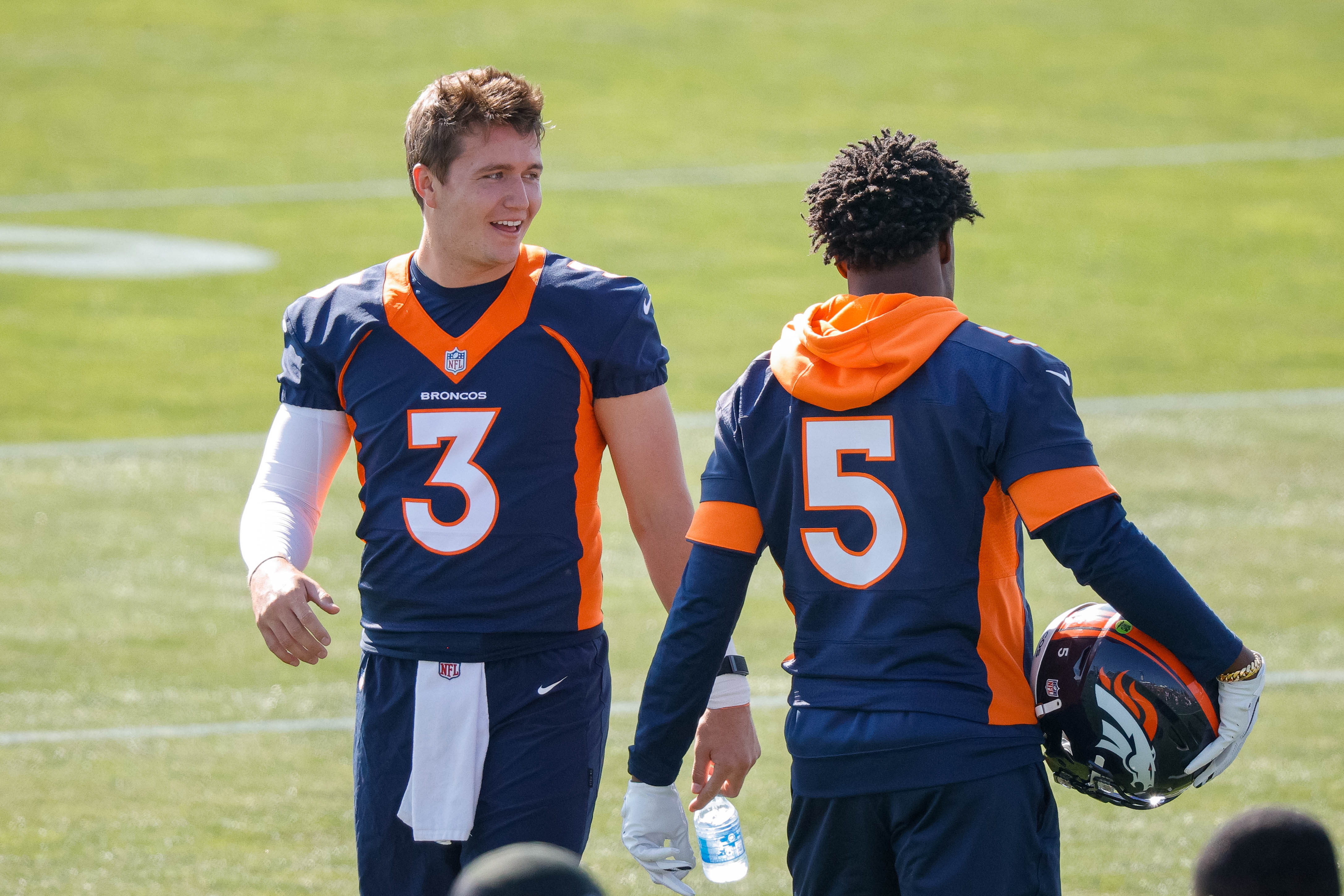 Denver Broncos quarterback Drew Lock (3) talks with quarterback Teddy Bridgewater (5) during training camp at UCHealth Training Complex.