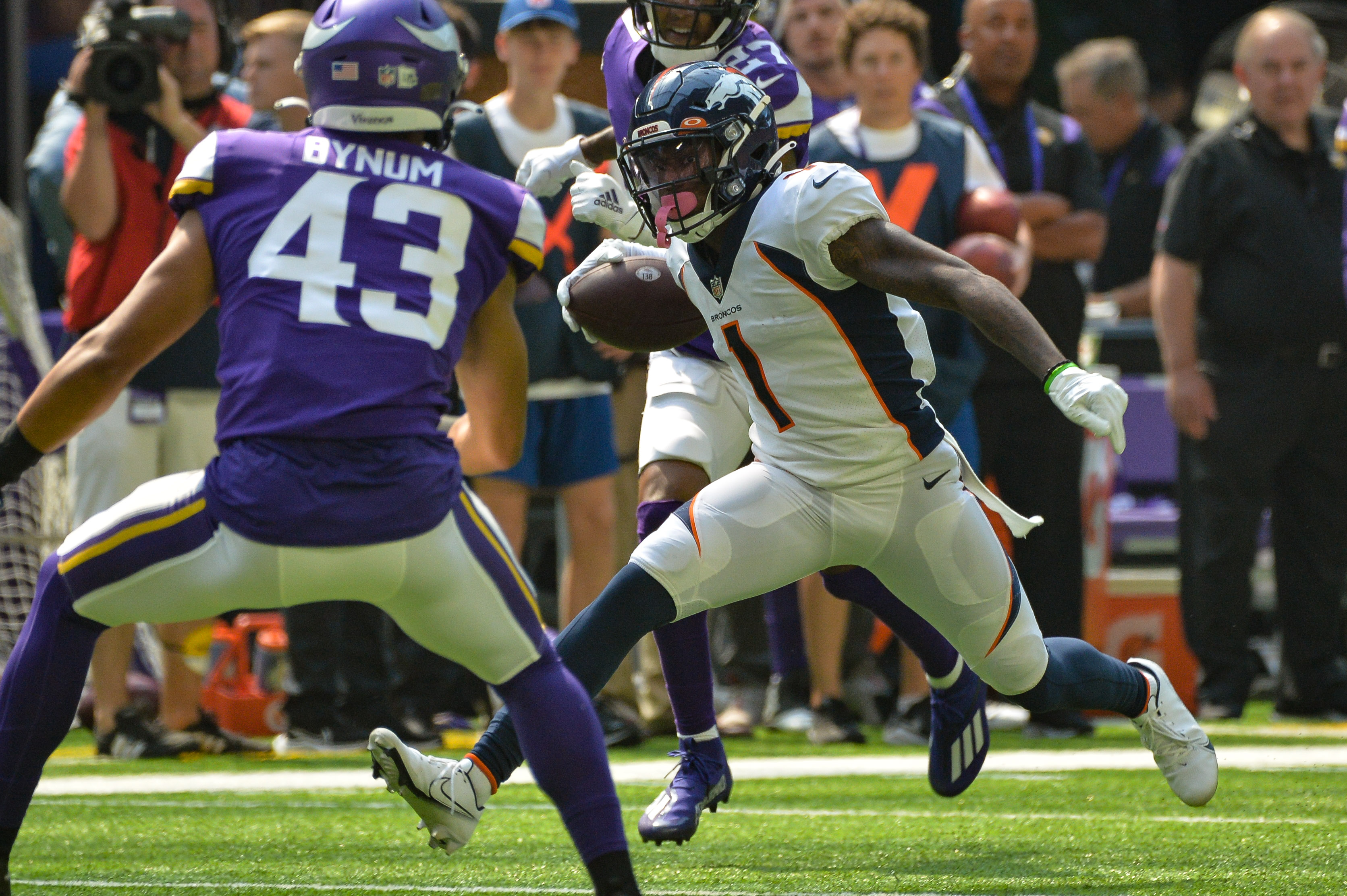 Denver Broncos wide receiver K.J. Hamler (1) runs the ball as Minnesota Vikings cornerback Camryn Bynum (43) defends during the first quarter at U.S. Bank Stadium.