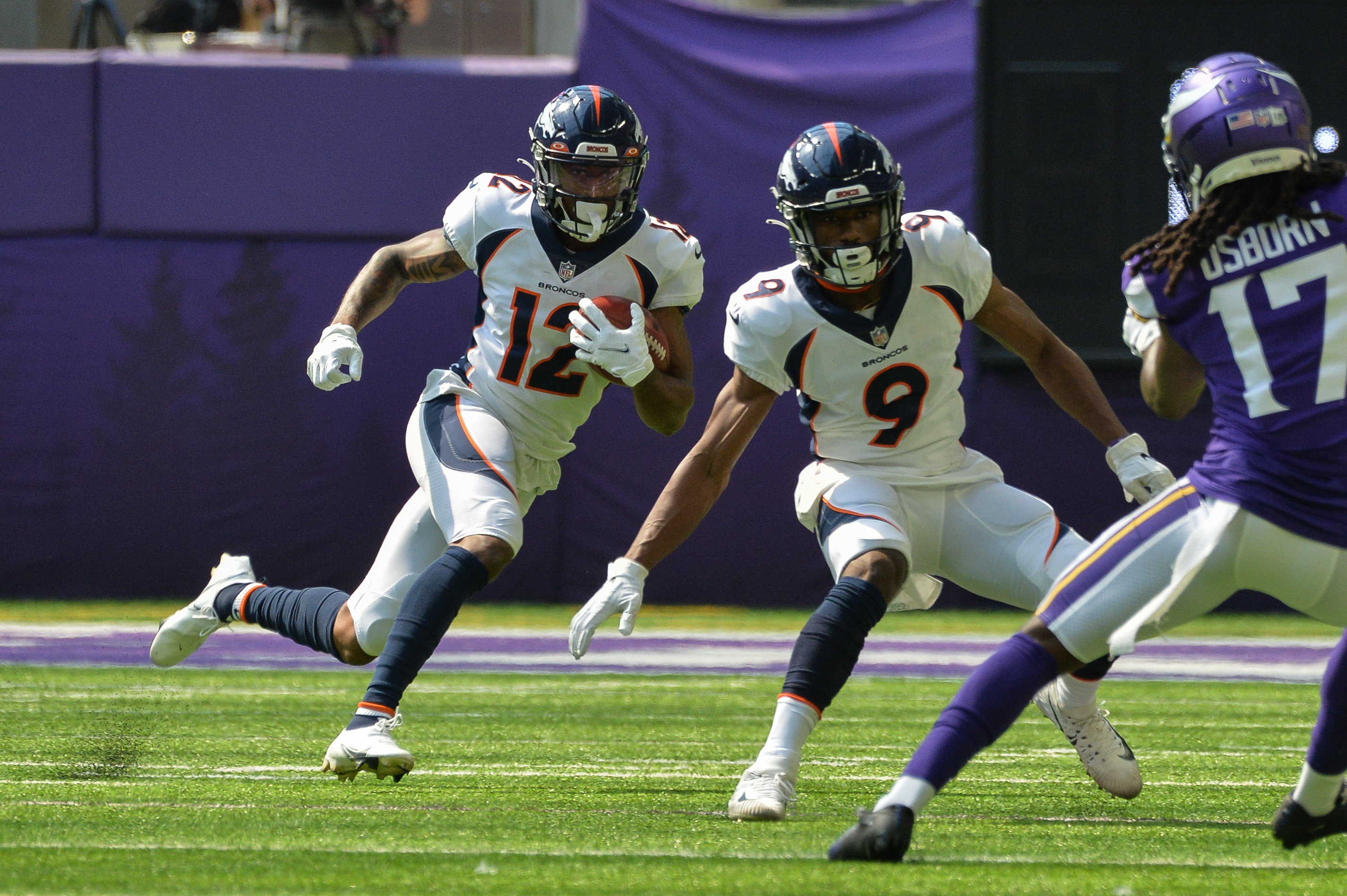 Denver Broncos wide receiver Trinity Benson (12) runs the ball as wide receiver Kendall Hinton (9) goes to block Minnesota Vikings wide receiver K.J. Osborn (17) during the first quarter at U.S. Bank Stadium.