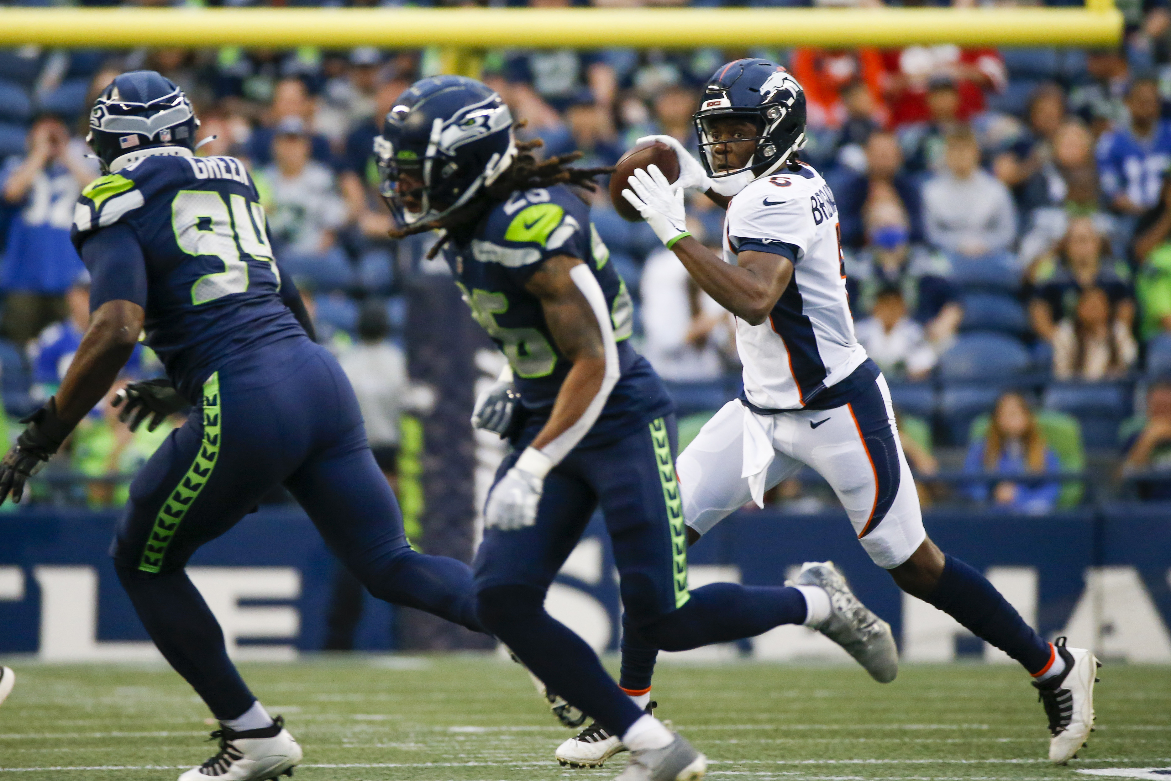 Denver Broncos quarterback Teddy Bridgewater (5) scrambles out of the pocket to pass against the Seattle Seahawks during the first quarter at Lumen Field.