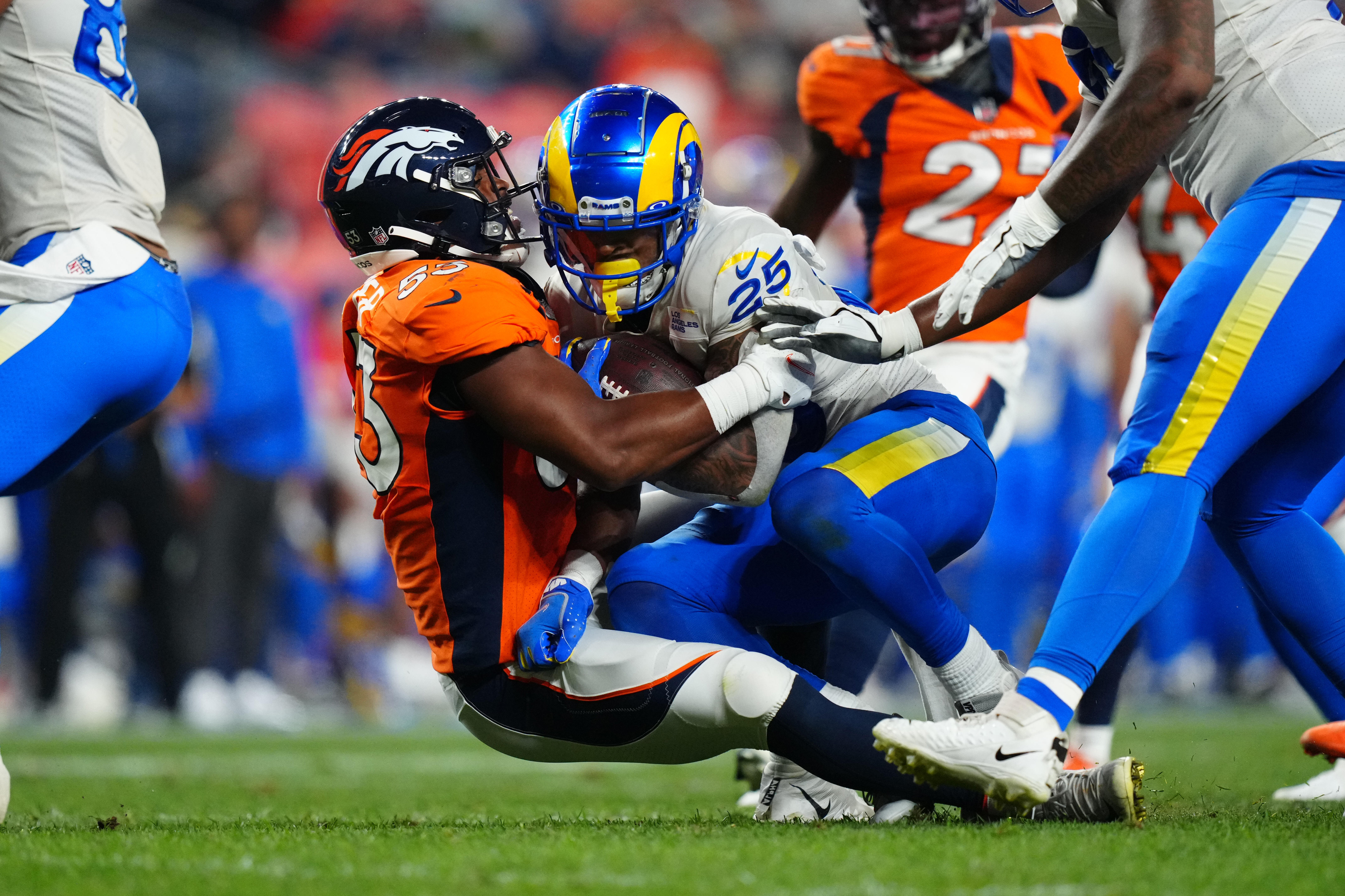 Denver Broncos linebacker Jonathon Cooper (53) tackles Los Angeles Rams running back Xavier Jones (25) in the second quarter at Empower Field at Mile High.