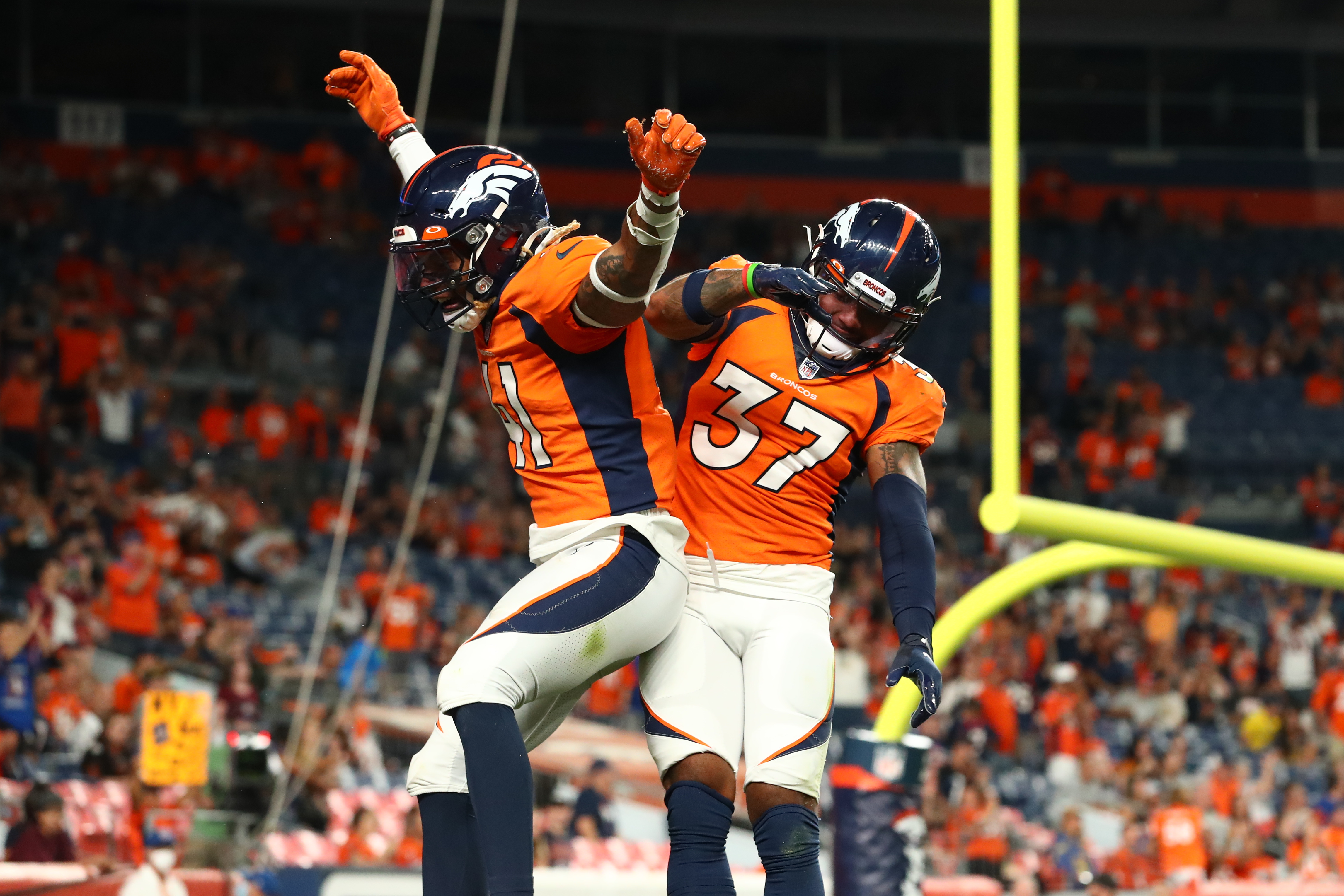 Denver Broncos safety Jamar Johnson (41) and defensive back P.J. Locke (37) celebrate after a defensive stop against the Los Angeles Rams during the fourth quarter at Empower Field at Mile High.
