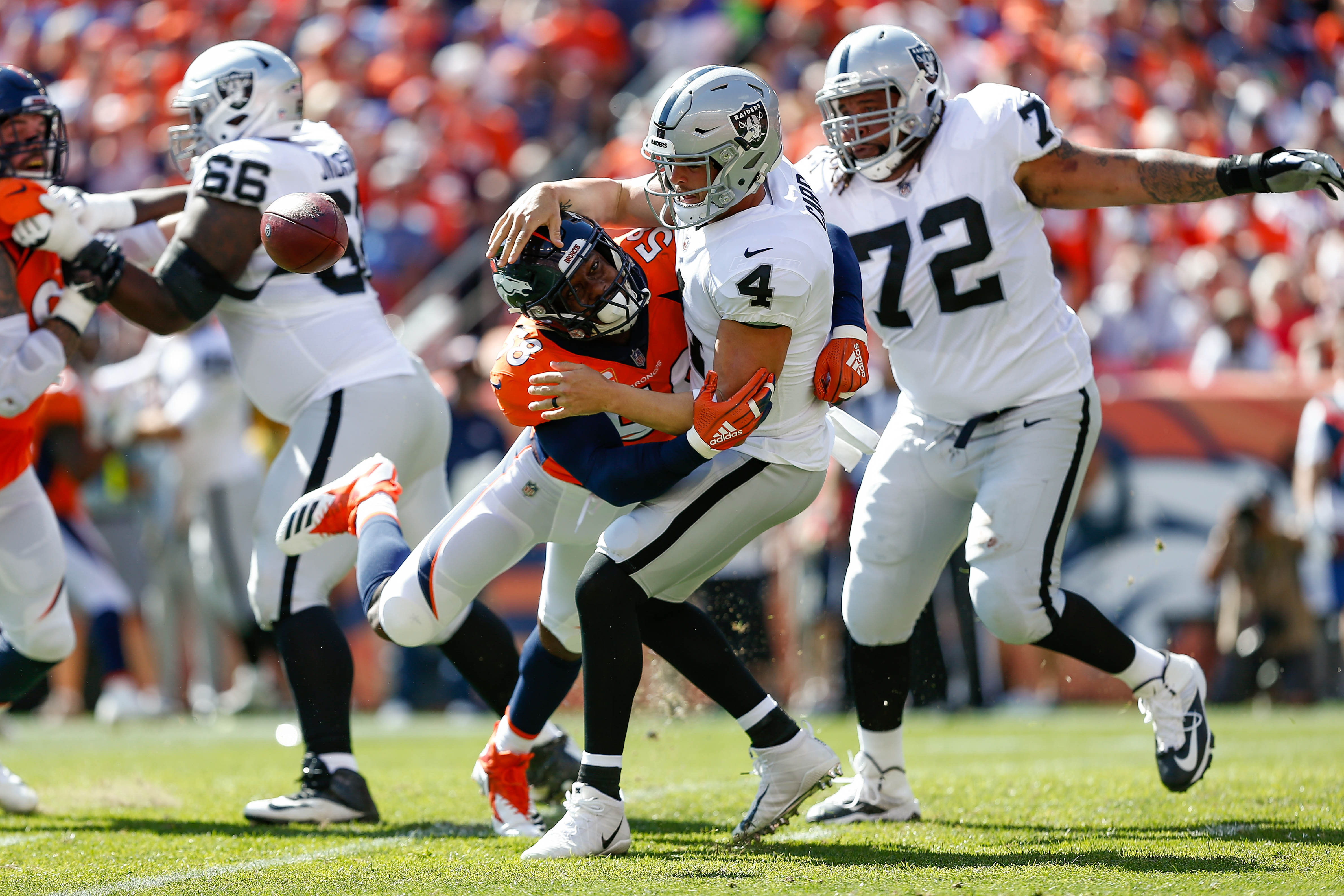 Denver Broncos outside linebacker Von Miller (58) strip sacks Oakland Raiders quarterback Derek Carr (4) as Oakland Raiders offensive tackle Donald Penn (72) defends, but the play would be called back on a defensive penalty in the first quarter at Broncos Stadium at Mile High