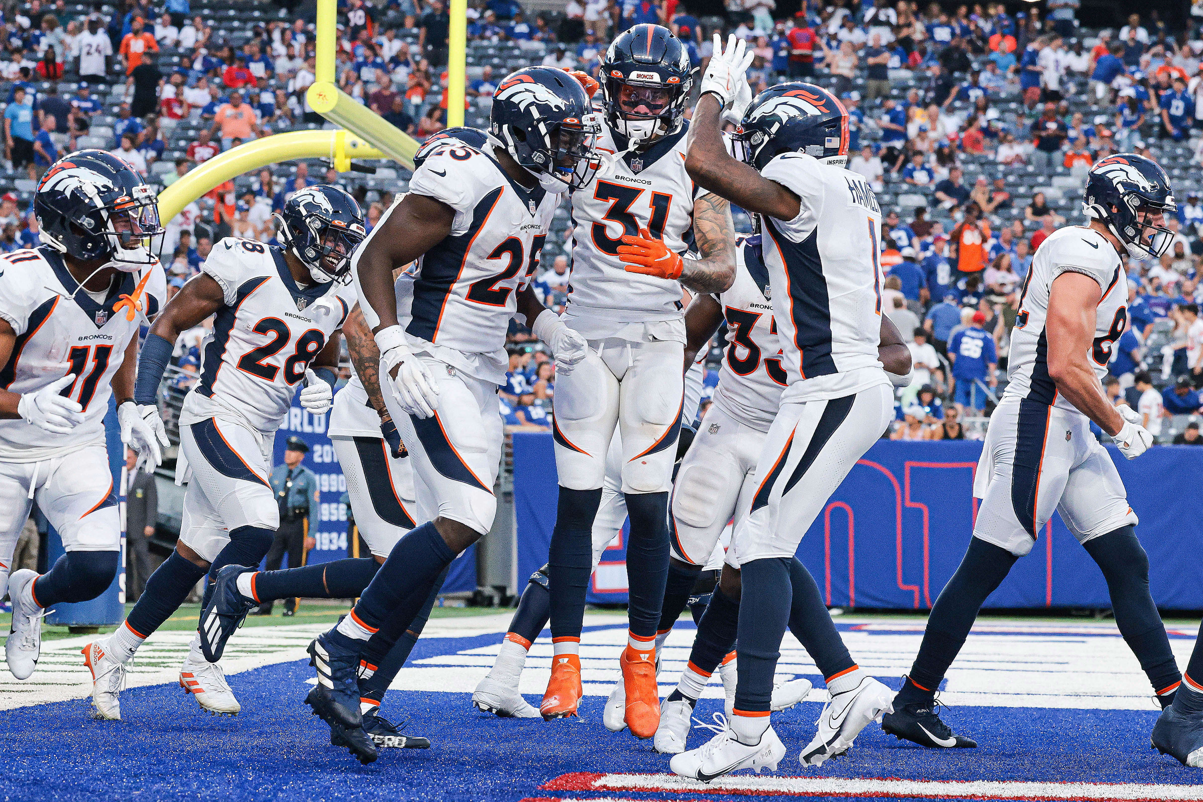 Denver Broncos running back Melvin Gordon (25) celebrates his touchdown with teammates during the second half against the New York Giants at MetLife Stadium.