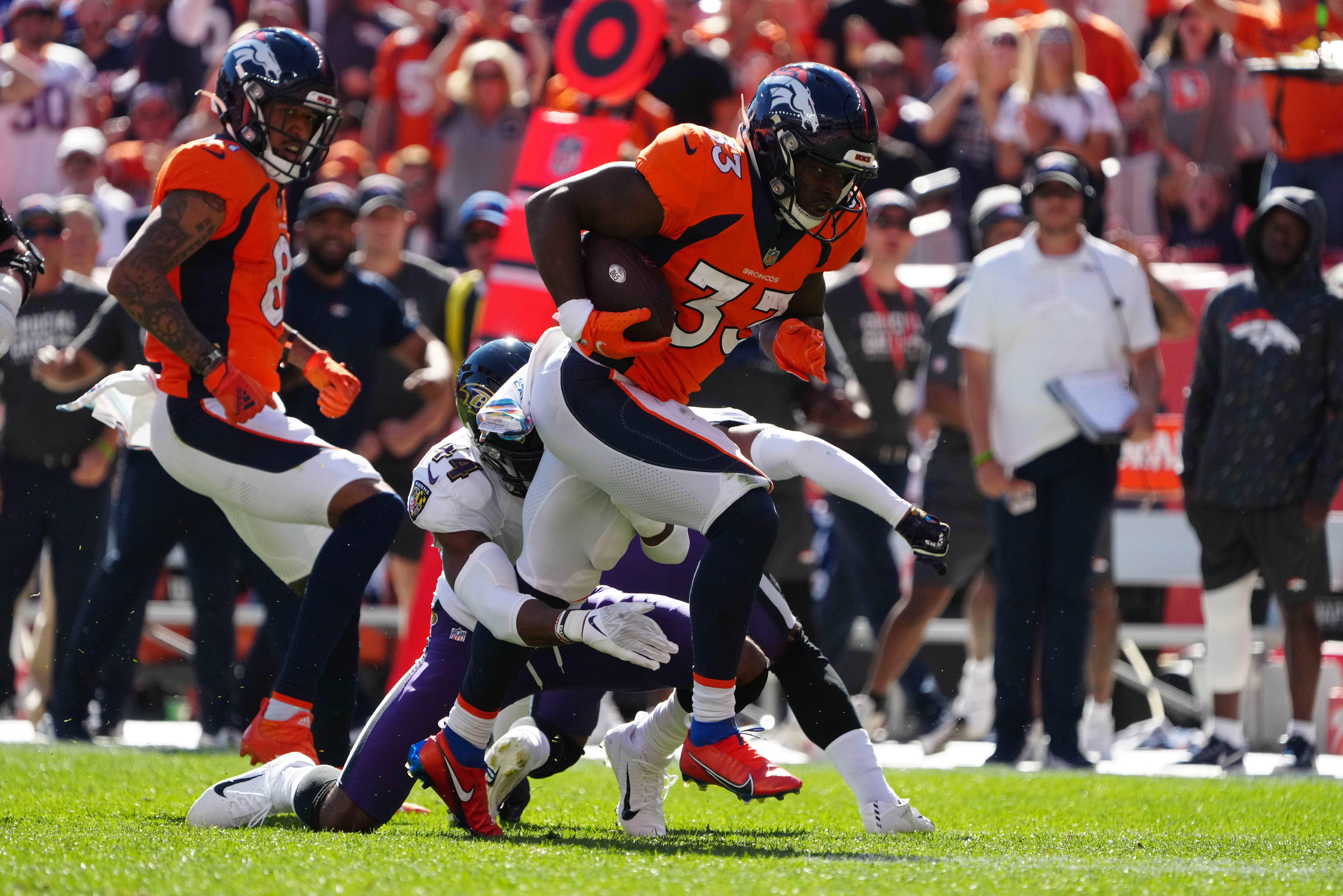 Baltimore Ravens cornerback Marlon Humphrey (44) attempts to tackle Denver Broncos running back Javonte Williams (33) in the first quarter at Empower Field at Mile High.