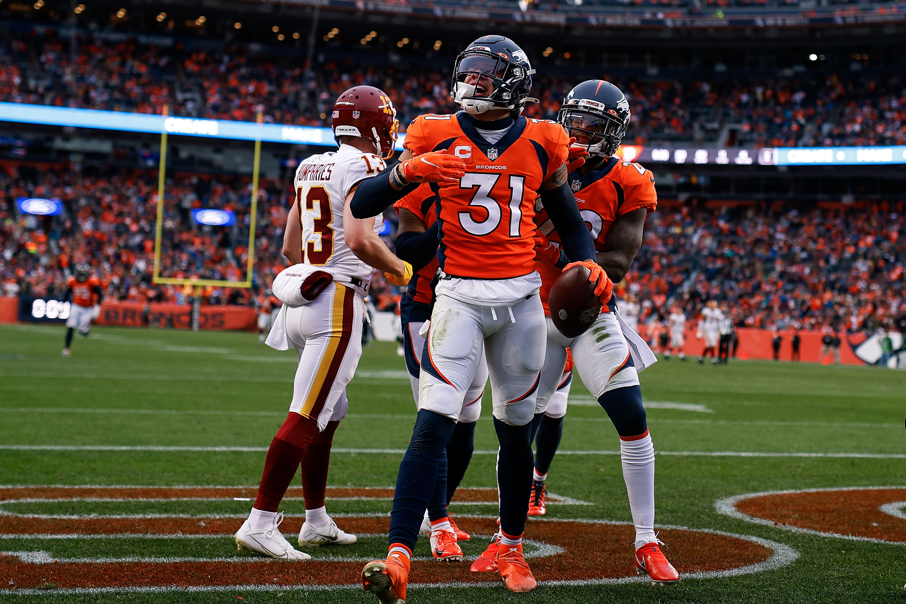 Denver Broncos safety Justin Simmons (31) celebrates with safety Kareem Jackson (22) after an interception in the second quarter against the Washington Football Team at Empower Field at Mile High.
