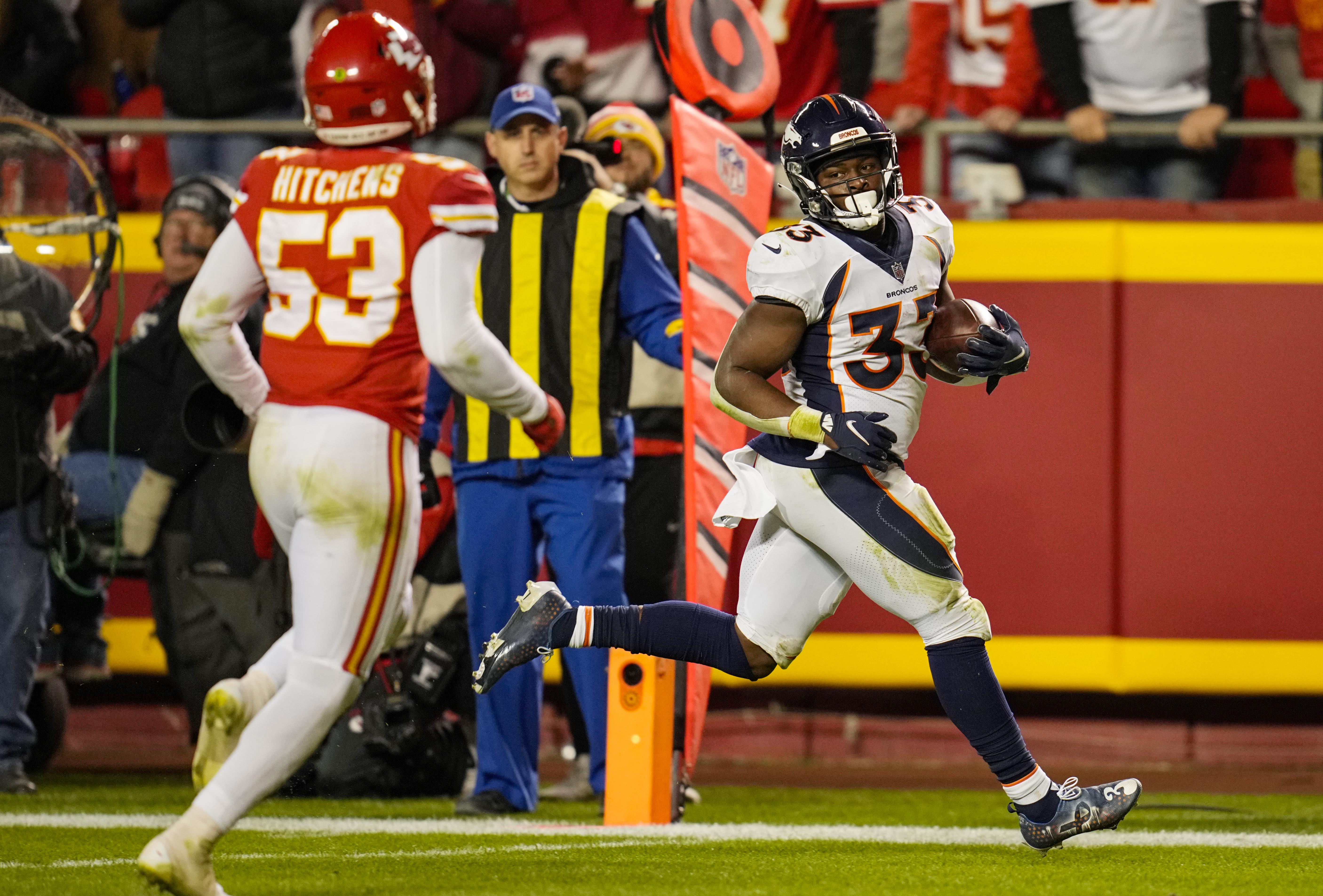 Denver Broncos star running back Javonte Williams (33) runs for a touchdown as Kansas City Chiefs linebacker Anthony Hitchens (53) defends during the second half at GEHA Field at Arrowhead Stadium.