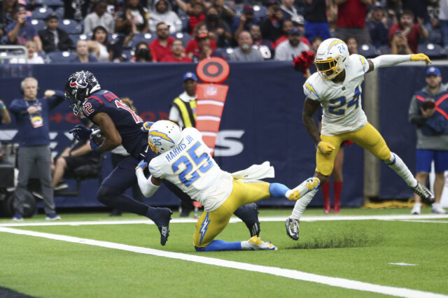 Houston Texans wide receiver Nico Collins (12) scores a touchdown as Los Angeles Chargers cornerback Chris Harris (25) defends during the fourth quarter at NRG Stadium.