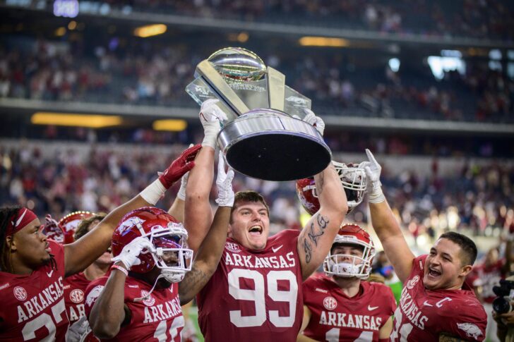 Arkansas Razorbacks defensive lineman Eric Thomas Jr. (37) and defensive lineman John Ridgeway (99) and linebacker Grant Morgan (31) hold up the Southwest Classic trophy as they celebrate the win over the Texas A&M Aggies at AT&T Stadium.