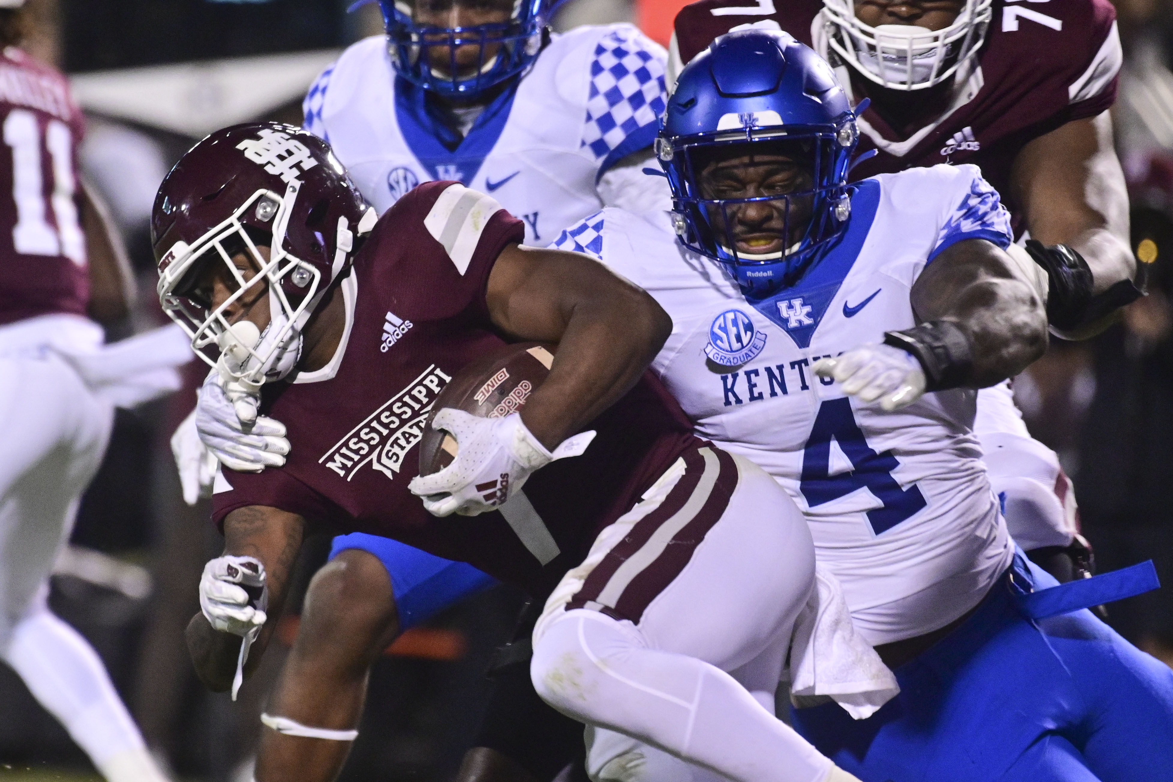 Mississippi State Bulldogs running back Jo'quavious Marks (7) runs the ball while defended by Kentucky Wildcats defensive end Josh Paschal (4) during the second quarter at Davis Wade Stadium at Scott Field.