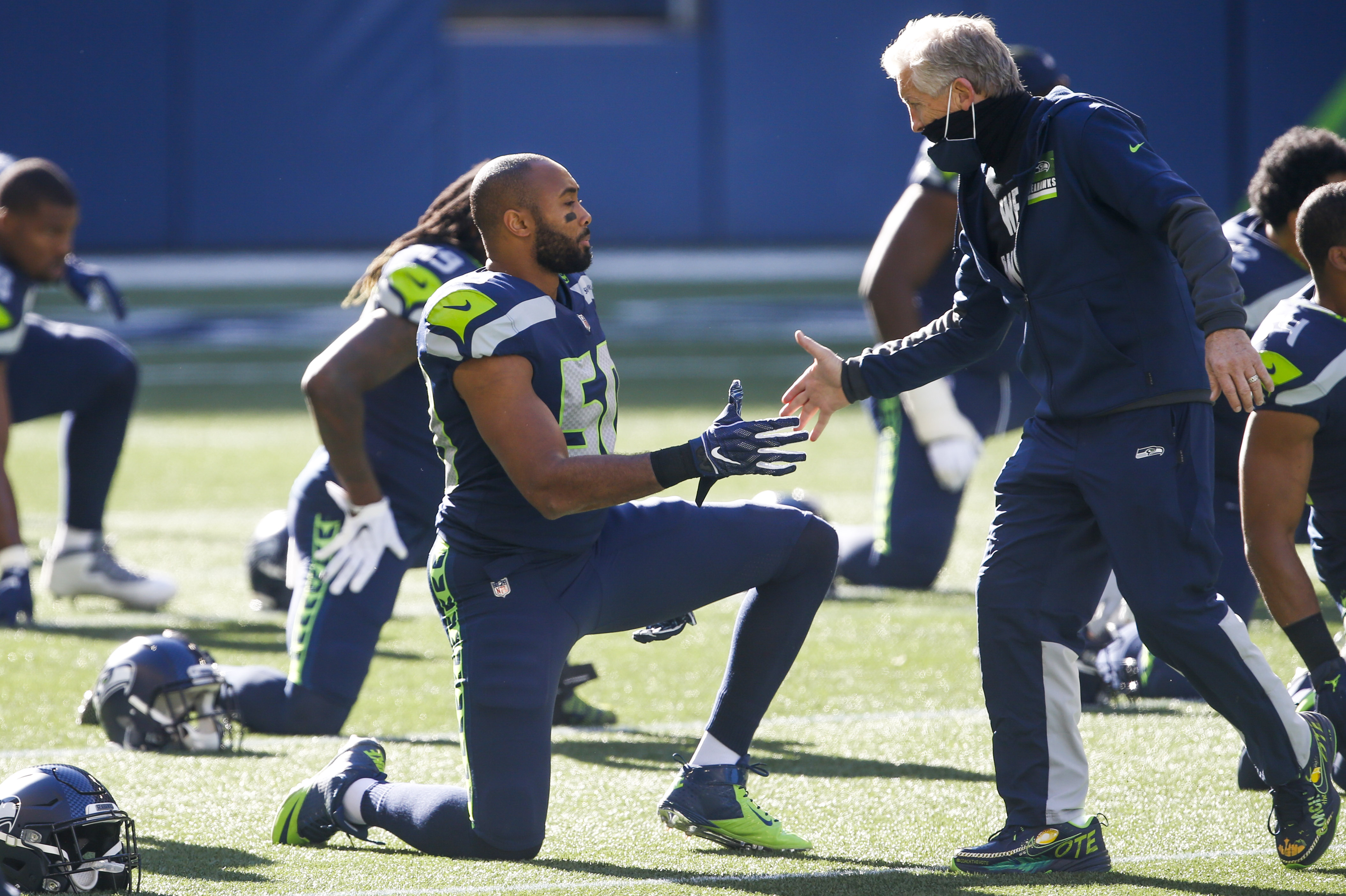 Seattle Seahawks head coach Pete Carroll greets outside linebacker K.J. Wright (50) during pregame warmups against the San Francisco 49ers at CenturyLink Field.