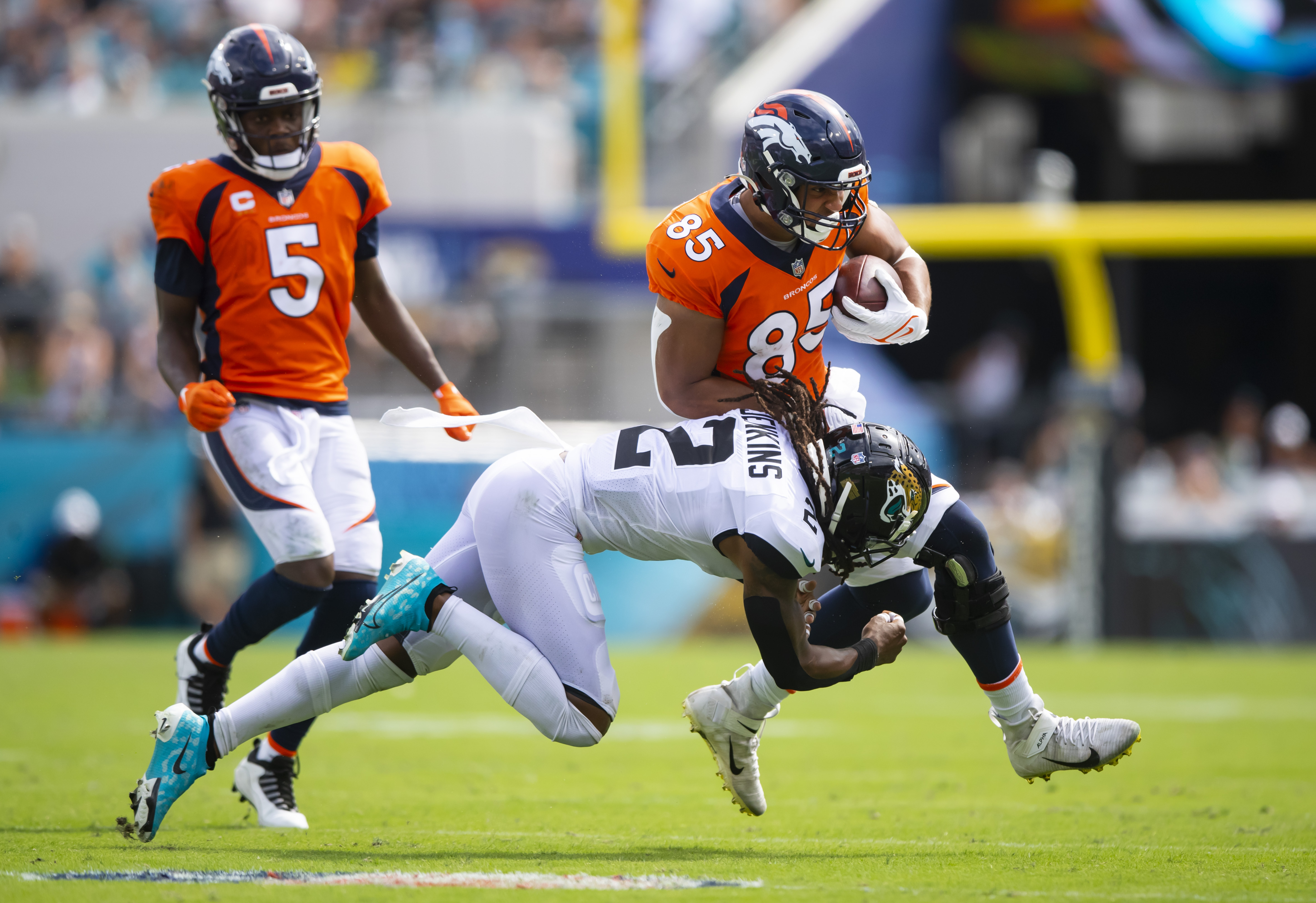 Jacksonville Jaguars safety Rayshawn Jenkins (2) tackles Denver Broncos tight end Albert Okwuegbunam (85) at TIAA Bank Field.