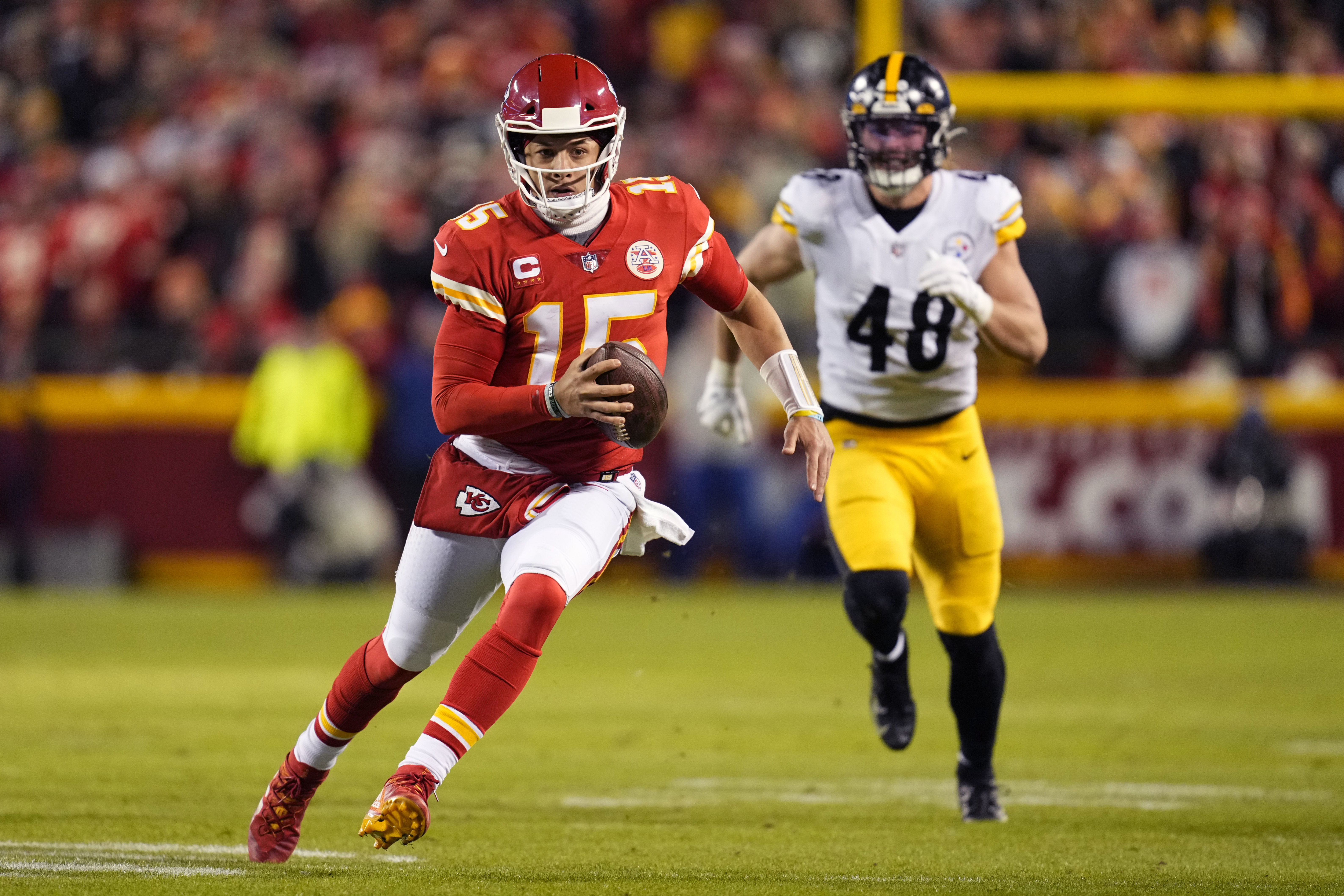 Kansas City Chiefs quarterback Patrick Mahomes (15) runs with the ball ahead of Pittsburgh Steelers linebacker Derrek Tuszka (48) in an AFC Wild Card playoff football game at GEHA Field at Arrowhead Stadium.