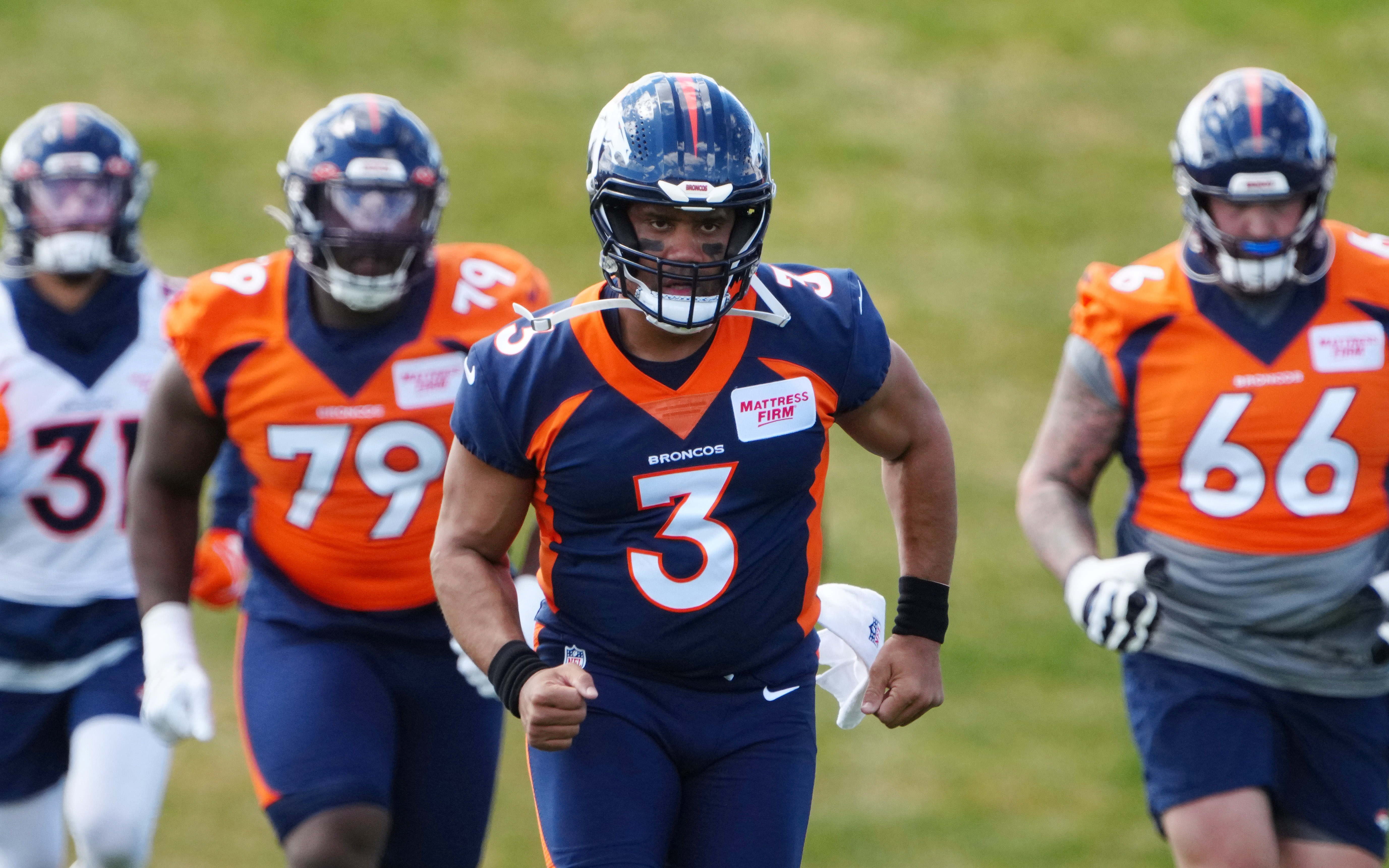 Russell Wilson leads Broncos teammates at practice in May. Credit: Ron Chenoy, USA TODAY Sports.