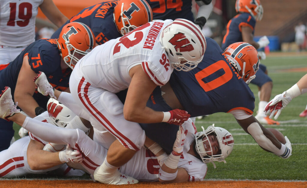Wisconsin Badgers safety Collin Wilder (18) and teammate Matt Henningsen (92) tackle Illinois Fighting Illini running back Josh McCray (0) near the goal line in there first half at Memorial Stadium.