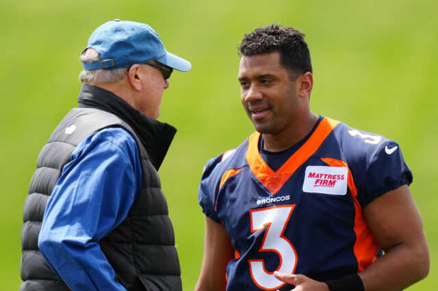 quarterback Russel Wilson (3) speaks to Paul Hackett father of head coach of the team during OTA workouts at the UC Health Training Center.