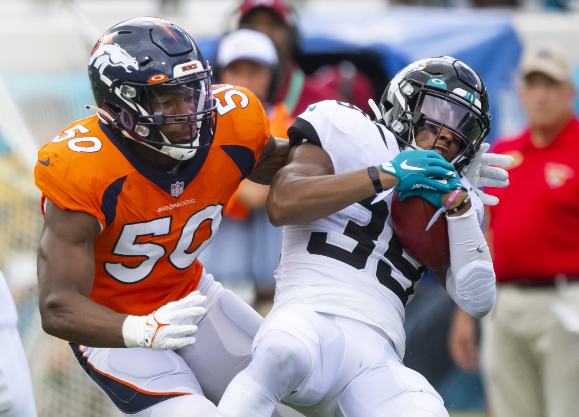 Jacksonville Jaguars wide receiver Jamal Agnew (39) is tackled by Denver Broncos linebacker Jonas Griffith (50) at TIAA Bank Field.