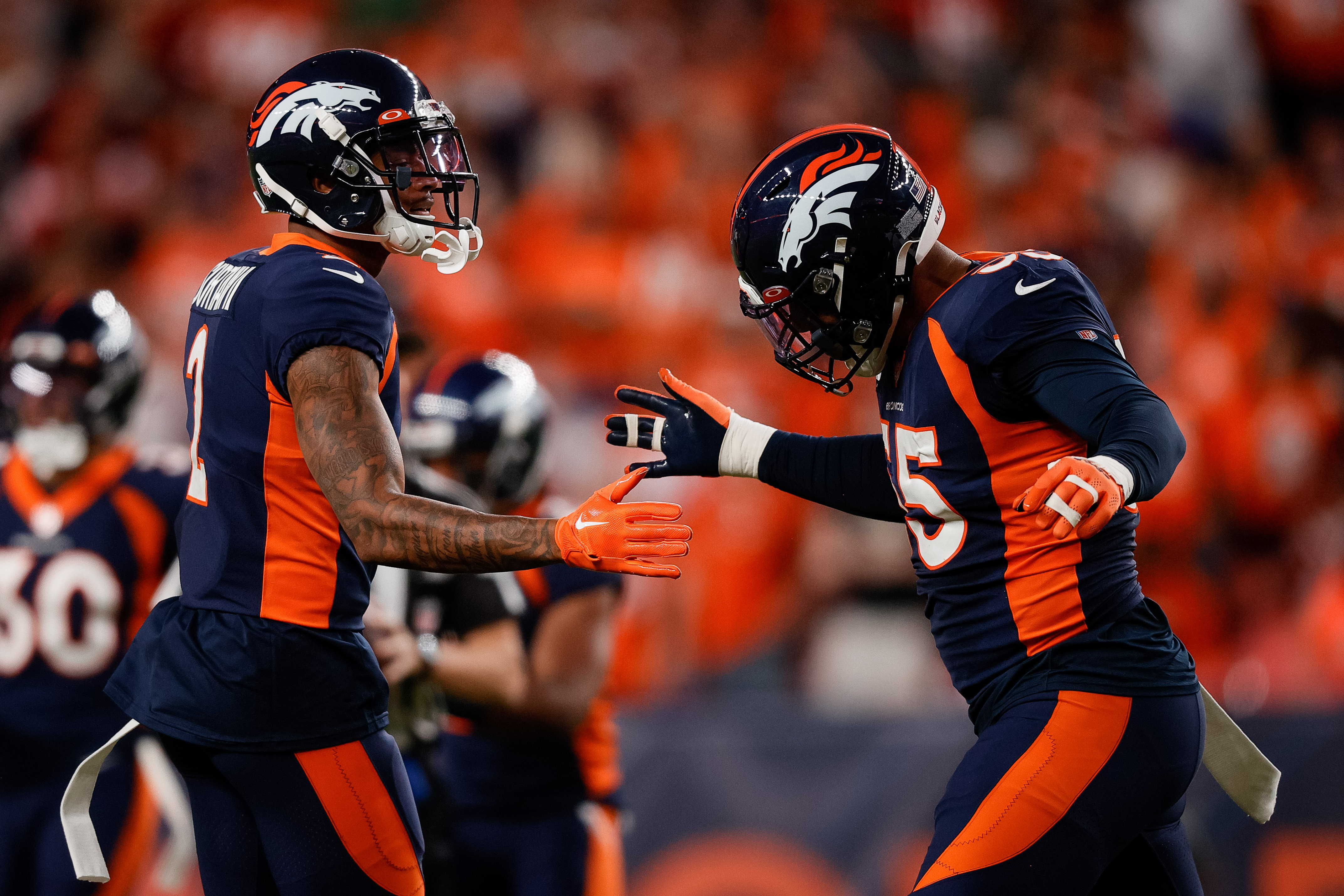 Denver Broncos cornerback Pat Surtain II (2) celebrates with linebacker Bradley Chubb (55) after a play in the first quarter against the San Francisco 49ers at Empower Field at Mile High.