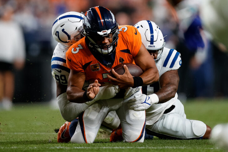 Denver Broncos quarterback Russell Wilson (3) is tackled by Indianapolis Colts defensive tackle DeForest Buckner (99) and defensive end Yannick Ngakoue (91) in the third quarter at Empower Field at Mile High.
