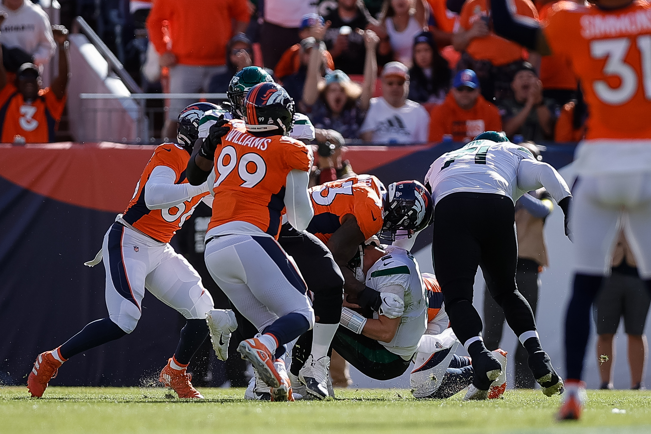 New York Jets quarterback Zach Wilson (2) is sacked by Denver Broncos defensive end Dre'Mont Jones (93) as defensive tackle DeShawn Williams (99) and linebacker Baron Browning (56) defend in the first quarter at Empower Field at Mile High. 