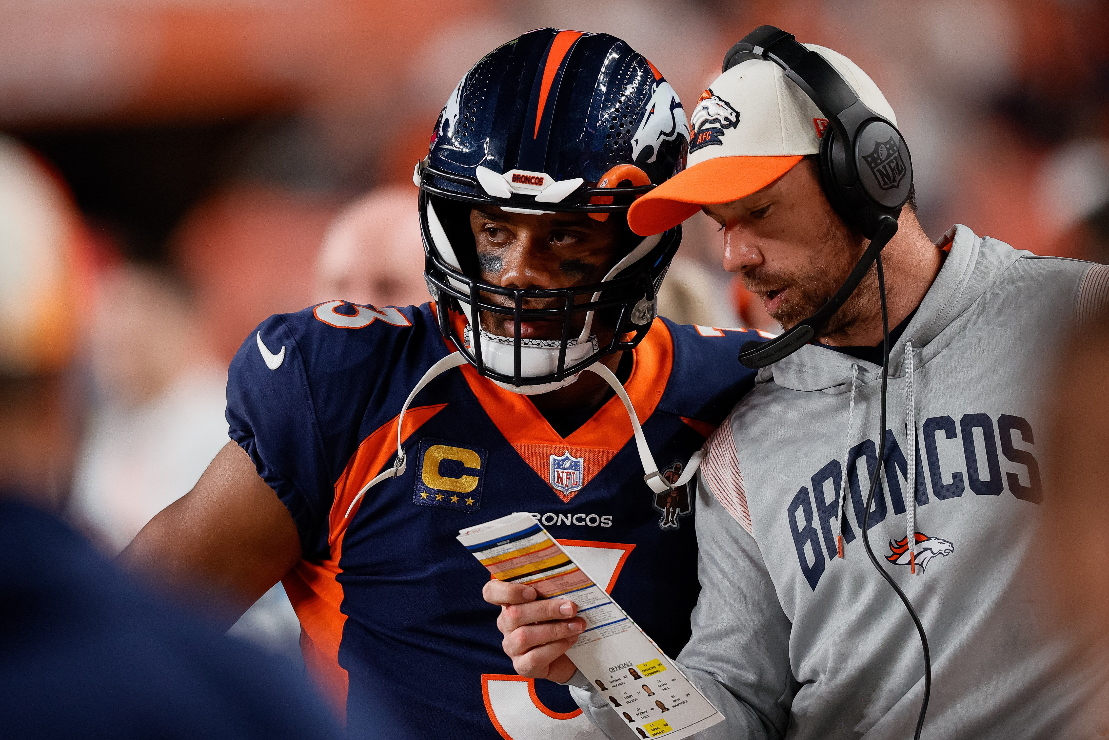 Denver Broncos quarterback Russell Wilson (3) talks with quarterbacks coach Klint Kubiak in the second quarter against the San Francisco 49ers at Empower Field at Mile High.