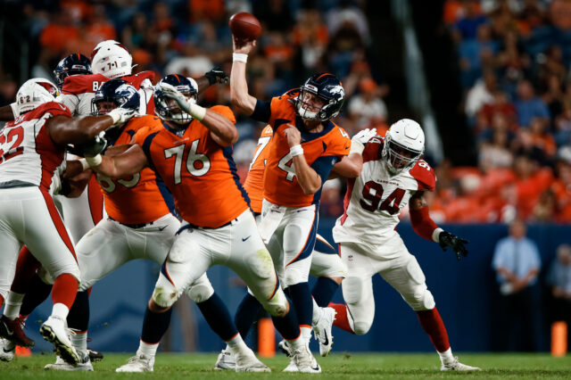 Denver Broncos quarterback Brett Rypien (4) attempts a pass under pressure from Arizona Cardinals linebacker Cameron Malveaux (94) as offensive lineman Adam Bisnowaty (76) defends in the fourth quarter at Broncos Stadium at Mile High.