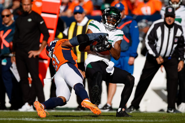 New York Jets wide receiver Garrett Wilson (17) is tackled by Denver Broncos cornerback K'Waun Williams (21) in the second quarter at Empower Field at Mile High.