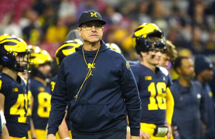 Michigan head coach Jim Harbaugh walks the sideline during the warm-ups prior to the Fiesta Bowl at State Farm Stadium.